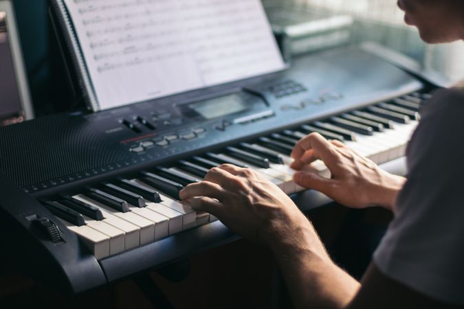 man playing piano with a music sheet