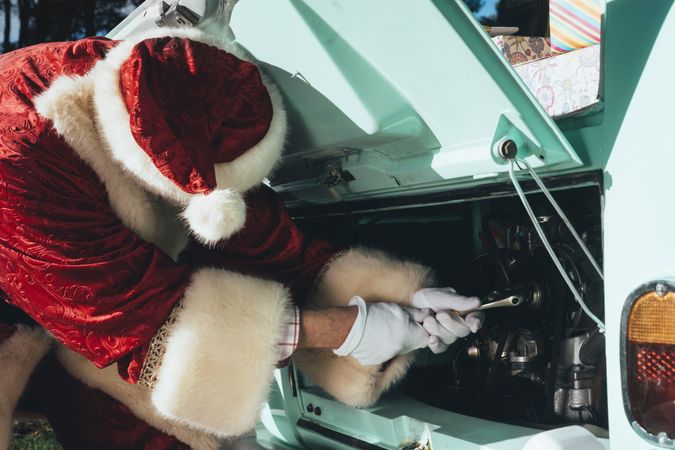 Santa Claus repairing old van