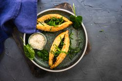 Two Georgian pies on plate with spinach and sesame seeds on a plate