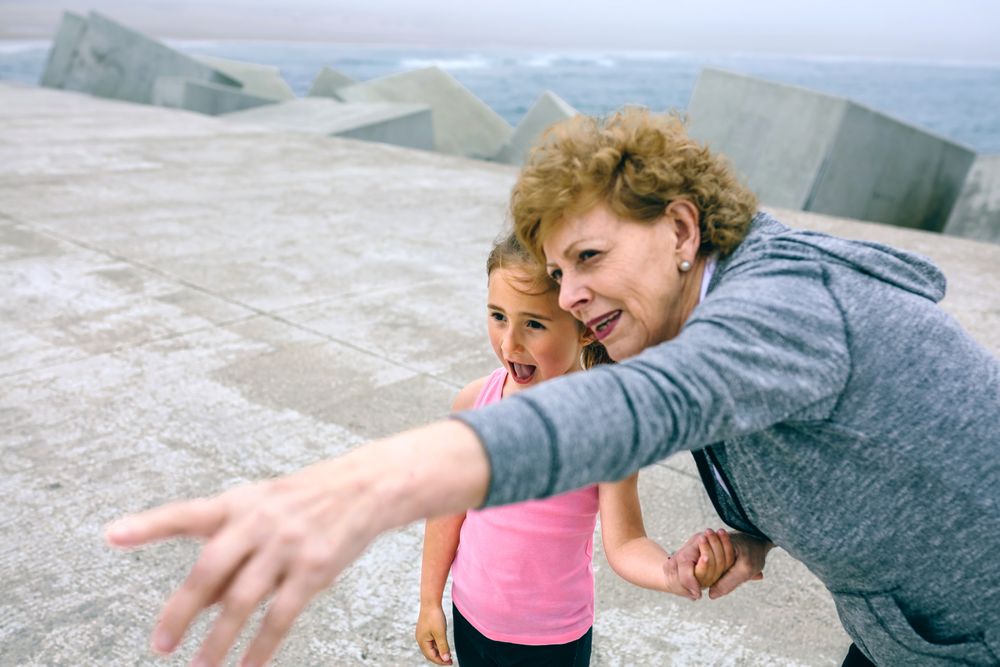 Mature sportswoman pointing with little girl