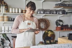 Florist preparing billing on tablet in her shop