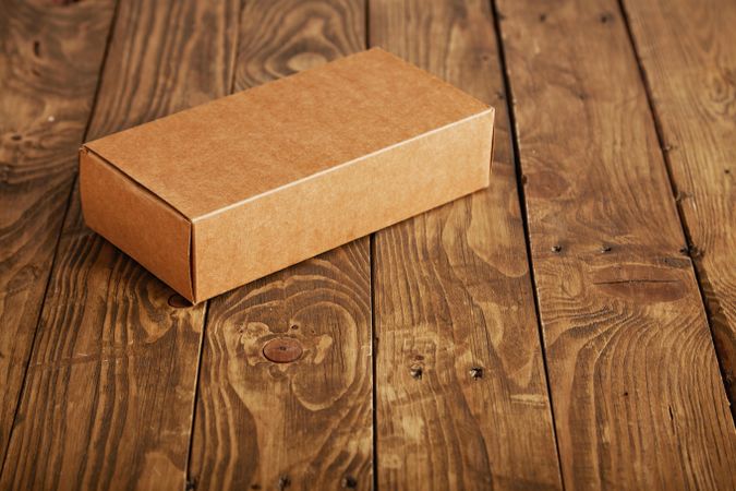 Rectangular cardboard box flat on wooden table