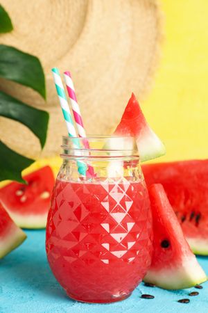 Composition with watermelon juice on blue table. Summer fruit