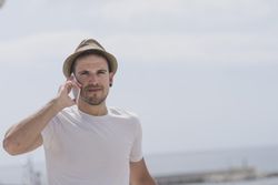 Male speaking on phone outside, copy space