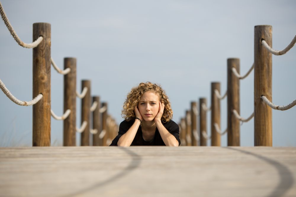 Young woman sitting on footbridge