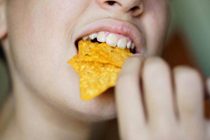 Girl biting nacho chips