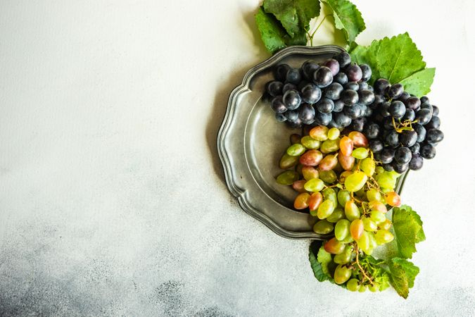 Top view of fresh red & green grapes on grey plate
