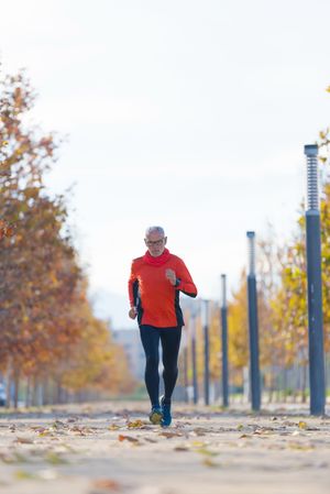 Healthy fit older male running in park