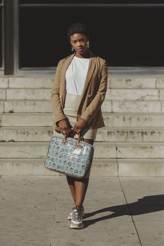 Stylish Black woman with handbag near steps on street