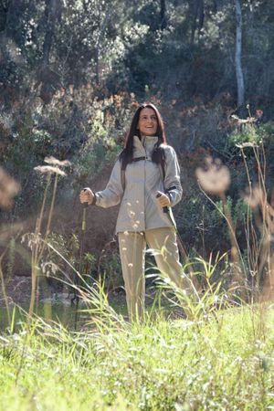 Hispanic woman with walking poles in nature