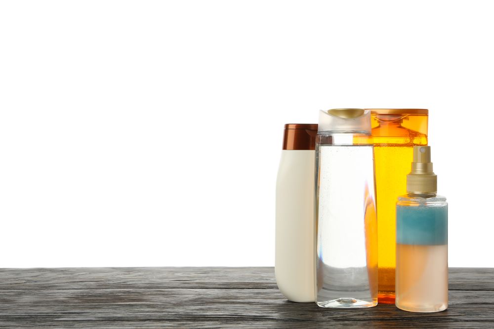 Blank cosmetics bottles on wooden table isolated on light background