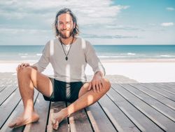 Man sitting on wooden pier on the beach