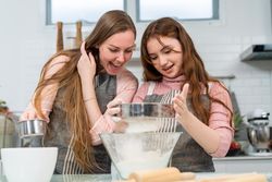 Woman and girl sieving flour