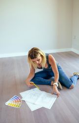 Woman looking house plans over the floor