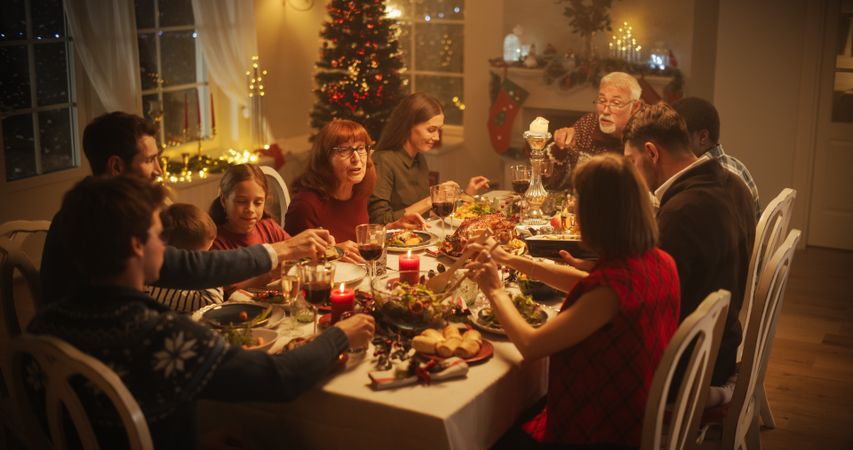 Diverse Group of People, Young and Old, Share a Joyful Christmas Dinner at Home.