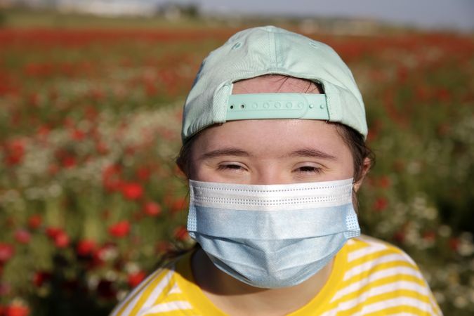Close up of young girl outdoors wearing a mask over face