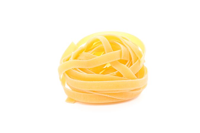 Pasta isolated on bright background, closeup. Dry uncooked whole pasta