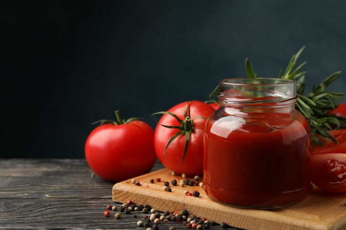 Composition with tomatoes and sauce on wooden background. Ripe vegetable