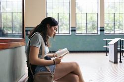 Woman reading a book in a train station