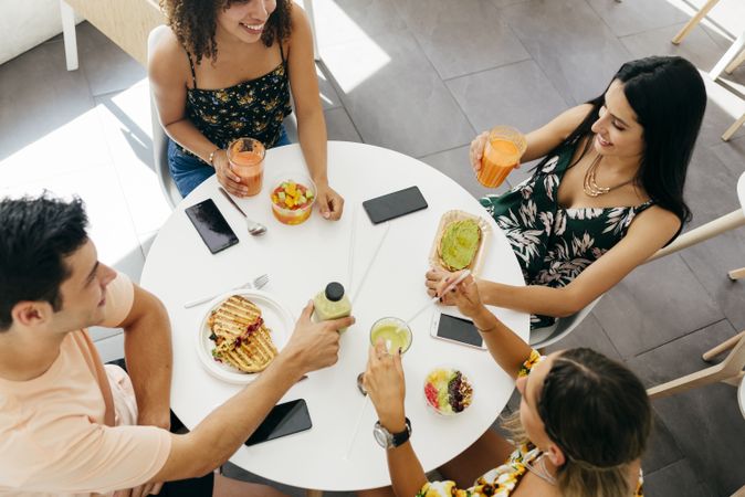 Diverse friends clinking glasses with smoothies