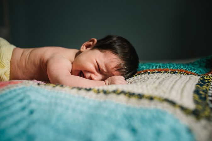 Crying baby on knitted blanket