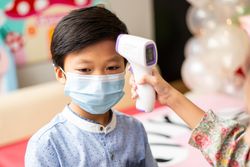 Boy having his temperature checked playing doctor