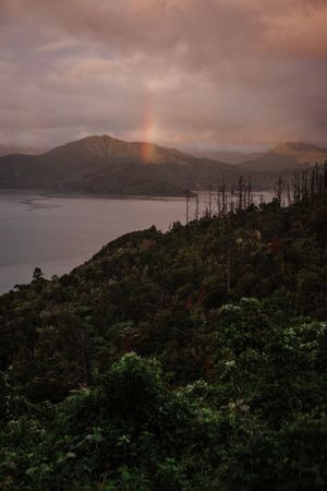 Rainbow over mountains on bay shore