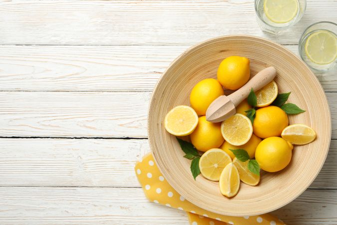 Lemonades and bowl with lemons on wooden background, top view