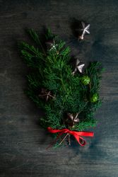 Tree branch with Christmas ornaments on wooden table