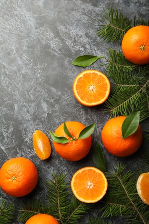 Mandarins and pine branches on gray smoky background