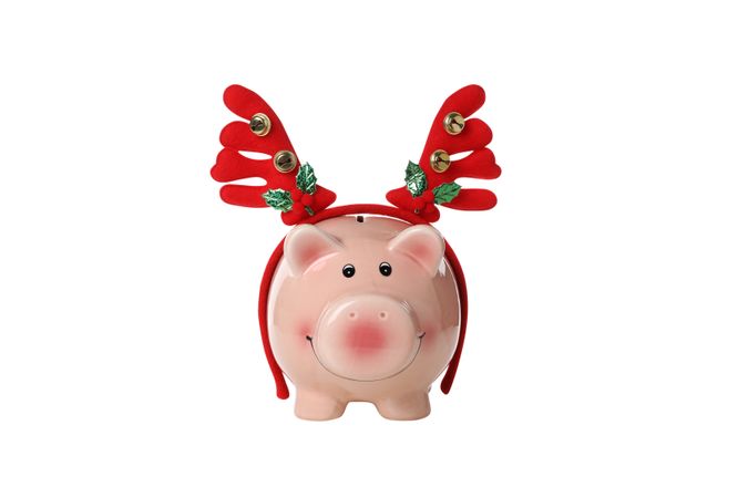 Piggy bank and Christmas deer antlers, isolated on light background