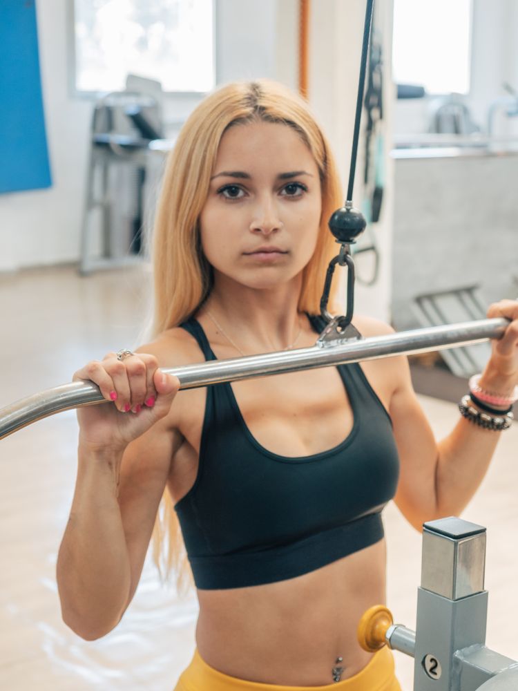Fit woman doing lat pull-down exercise
