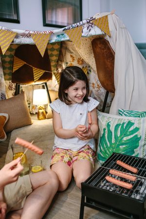 Happy girl eating sausage with her family