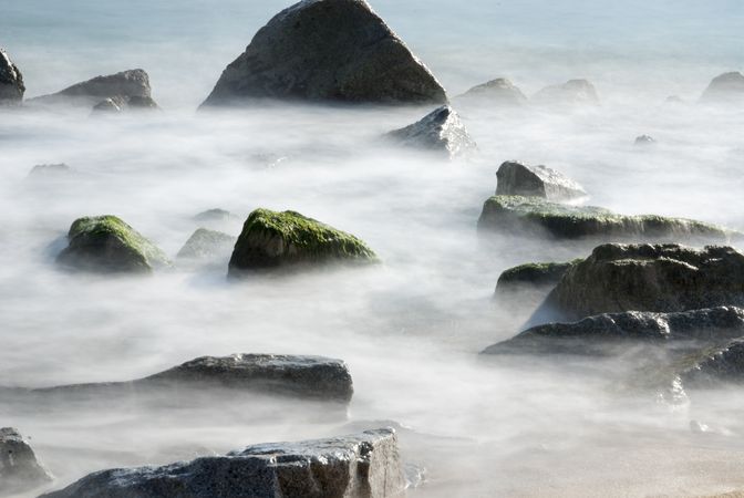 Rocks over the water with mist, Seaside of Badalona, Spain