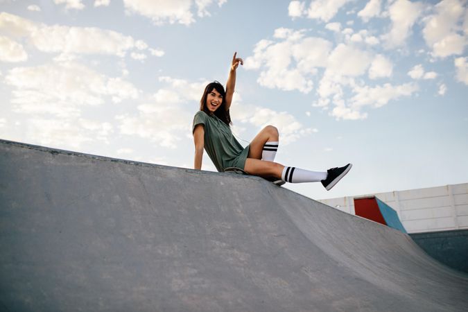 Skateboarder sitting on a ramp in skate park