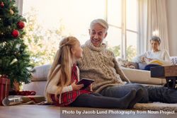 Mature man and granddaughter with digital tablet at home 0WOxAj