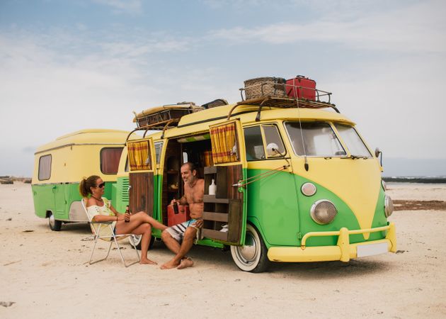 Friends in minibus with trailer on beach