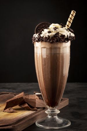 Chocolate milkshake with pieces of chocolate chip cookies.