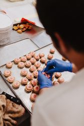 Anonymous baker decorating small cakes