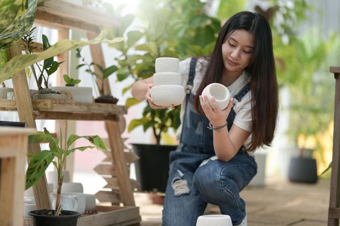 Asian female picking a variety plant pots at work