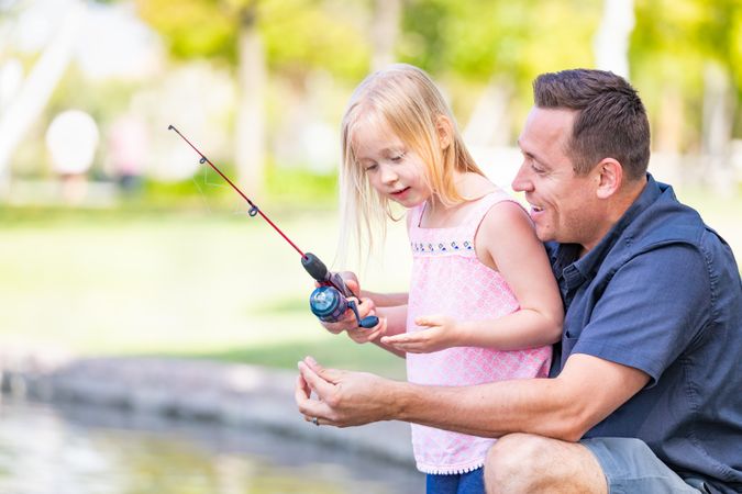 Young Father and Daughter Having Fun Fishing At The Lake