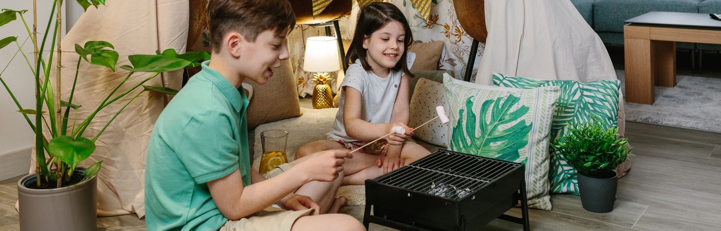 Brothers camping at home toasting marshmallows