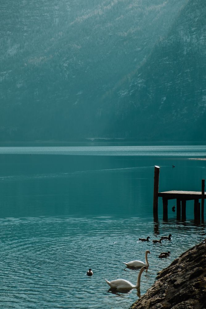 Lonely empty pier in turquoise water along mountain