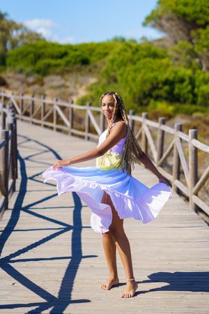 Carefree female dancing in colorful dress on a pedestrian walkway