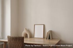 Blank picture frame mockup on wooden table, desk with rattan chair beX8Yq
