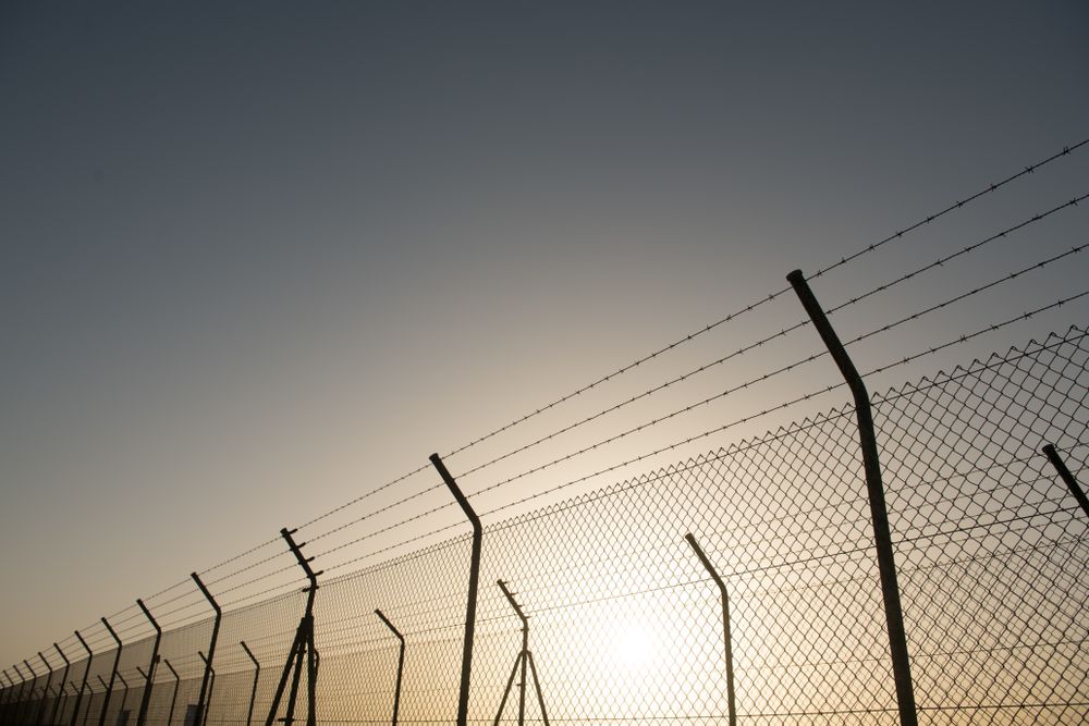 Bright sun behind security fence