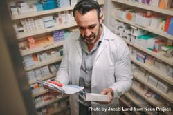 Male pharmacist searching for medicine in pharmacy 4MxXz5