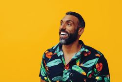 Happy male smiling in brightly patterned shirt, copy space