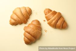 Three baked croissants on beige background, top view 5Rm7D0