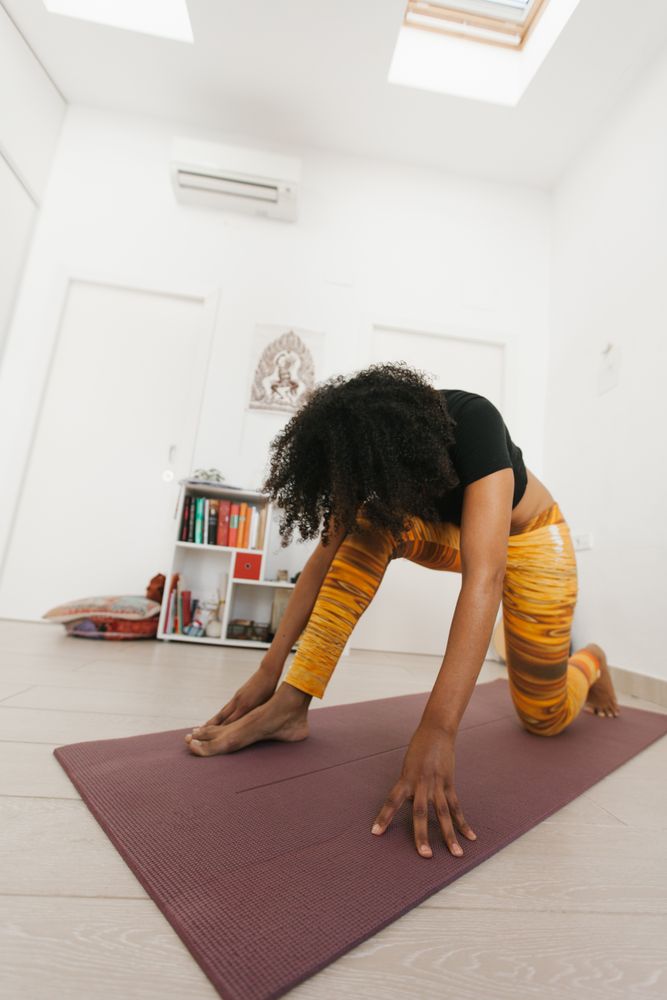 Sportive woman standing in yoga pose with head down
